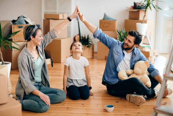 Two parents connects arms over child to form a room
