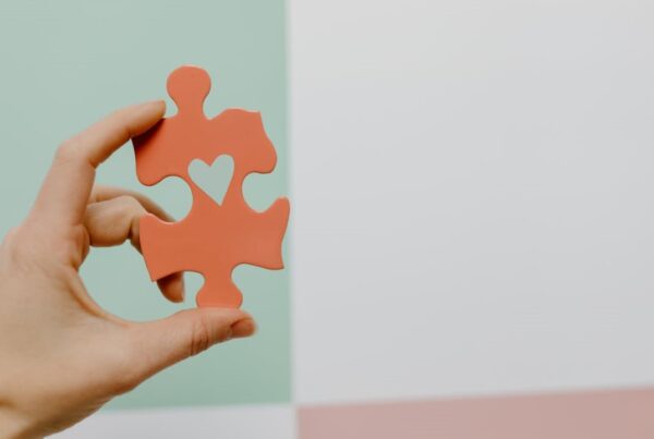 Orange puzzle piece with a heart cut into it