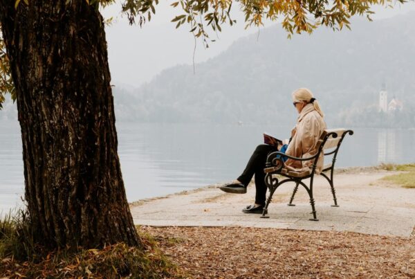 Woman reading on a bench near water