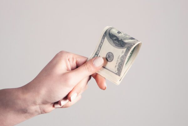 A hand reaching out and holding money