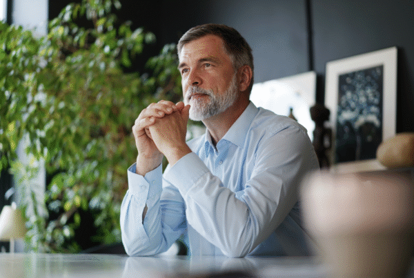 Late-career business owner pensively thinking in office